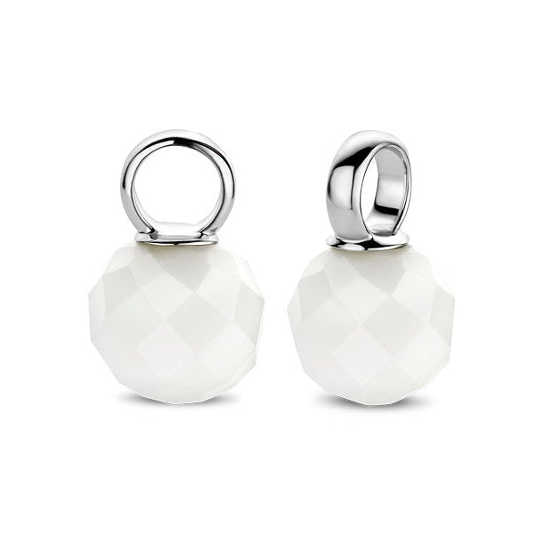 Two white round pendants with silver loops on a white background