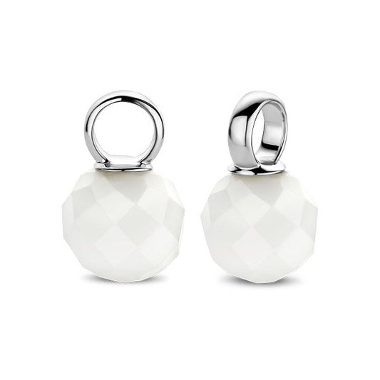 Two white round pendants with silver loops on a white background